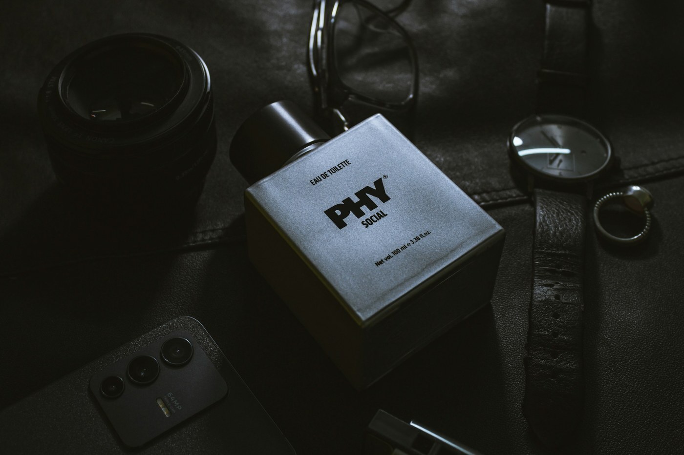 Styled flat lay of a fragrance box, watch, and phone, representing the lifestyle product images sellers use in Amazon A+ Content modules