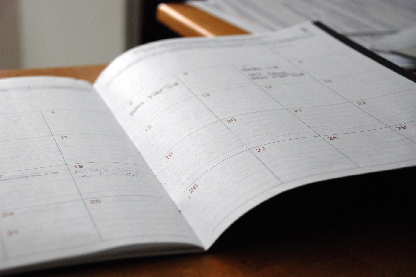 Open monthly planner on a wooden desk used for scheduling peak-season inventory moves from Amazon AWD into FBA