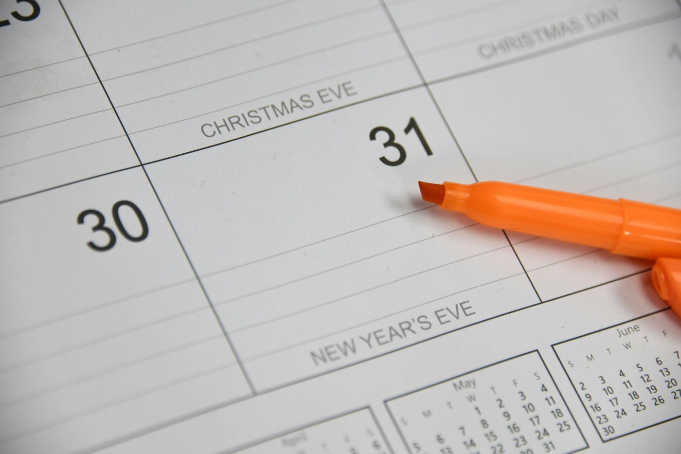 Paper wall calendar with highlighter marking year-end dates, representing Amazon Q4 inbound and peak-fee planning deadlines
