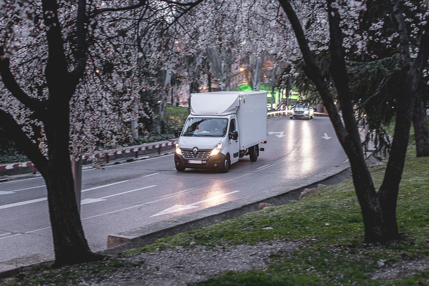 White box truck driving along a city road, representing Amazon MCF deliveries to customers outside Amazon
