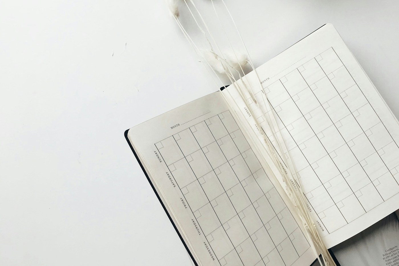 Open monthly planner on a white desk, representing the recurring delivery schedule customers set with Amazon Subscribe and Save