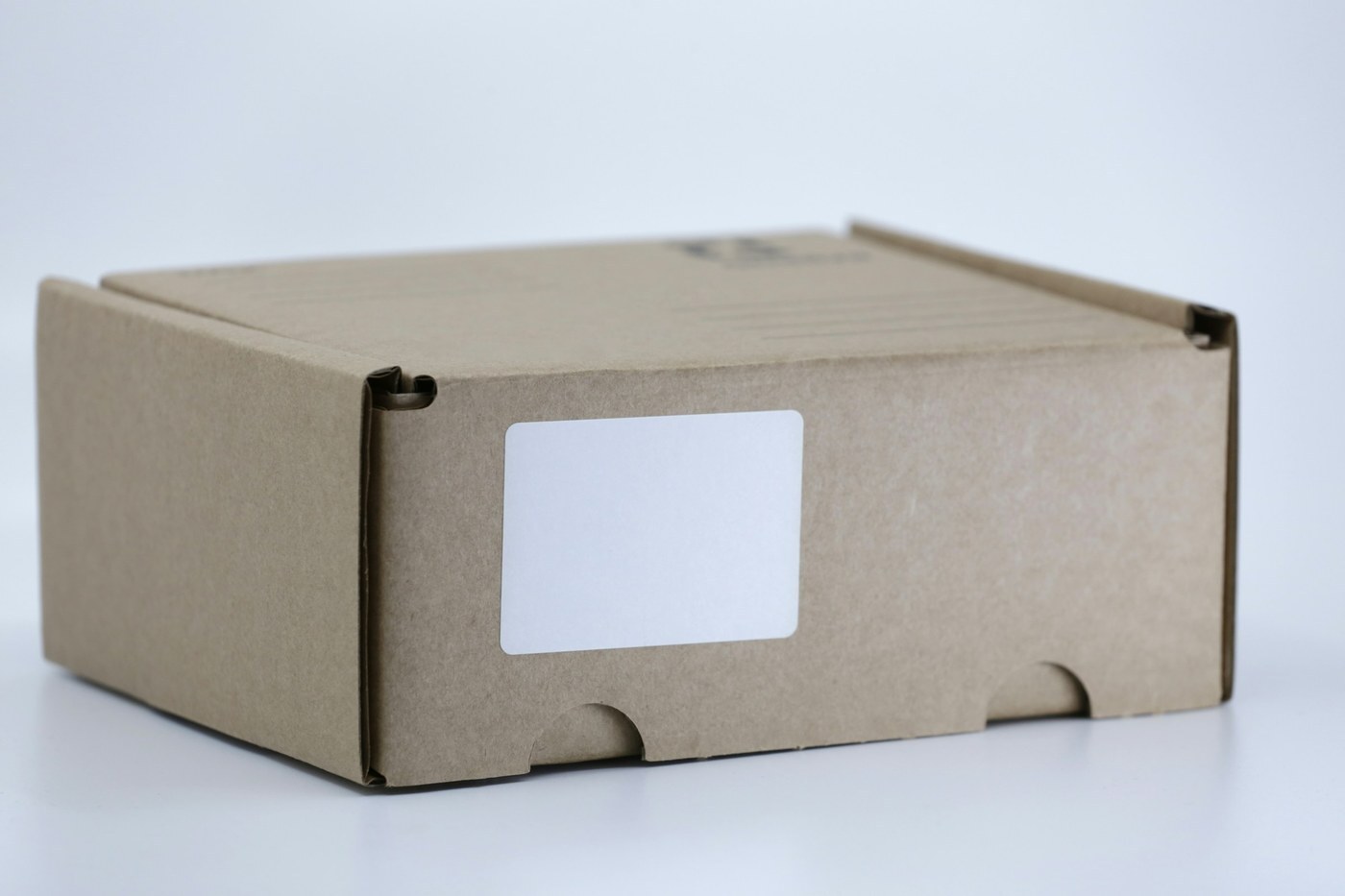 Corrugated shipping box with a blank white unit label ready for a Transparency code
