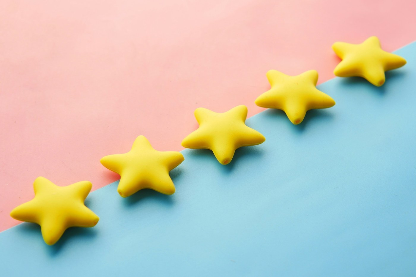Five yellow stars on a pink and blue background, representing Amazon customer ratings and Voice of the Customer CX Health