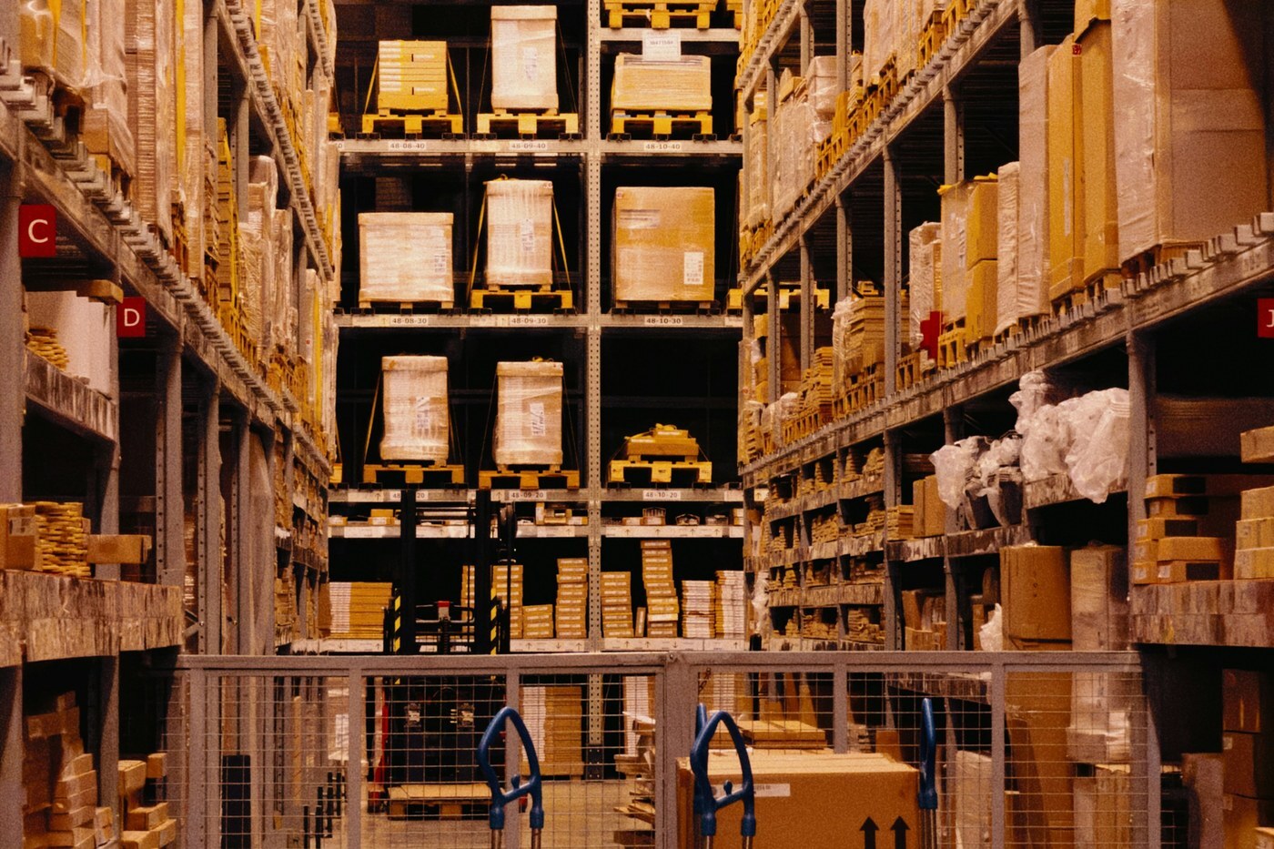 Tall warehouse racks stocked with cardboard boxes on pallets, representing FBA inventory levels and days of supply
