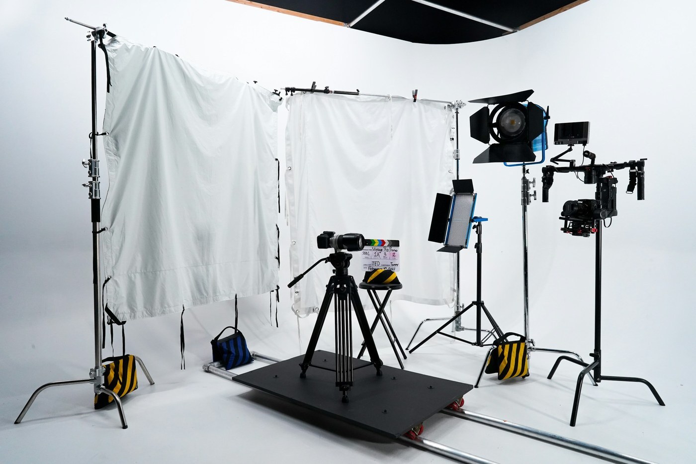 White photo studio with a camera on a tripod and lights, representing a setup for shooting Amazon product images