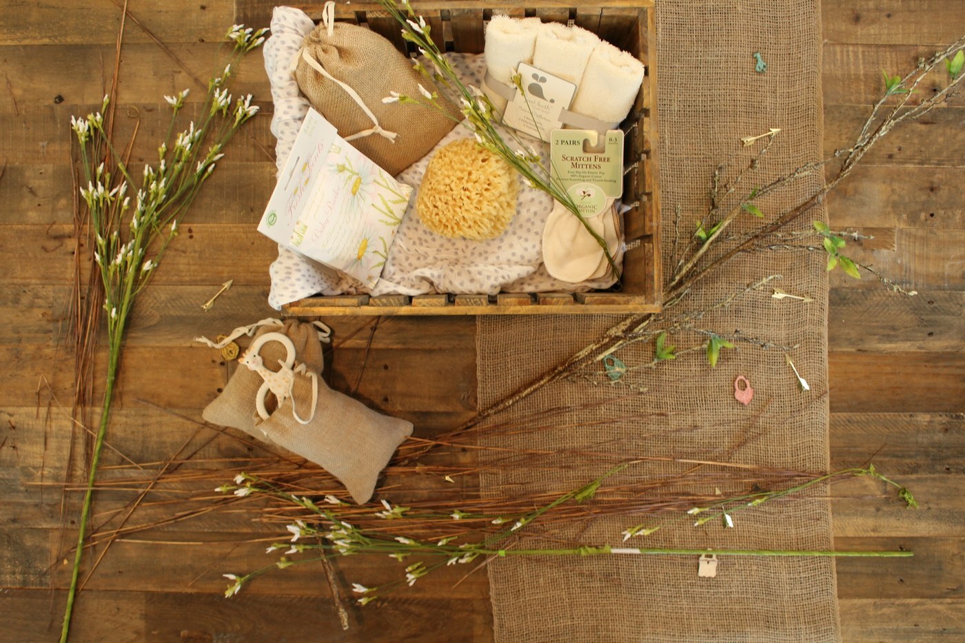 Wooden crate gift set of bath essentials including washcloths, a natural sponge, mittens, and soap pouches, representing a bundle of complementary products on Amazon