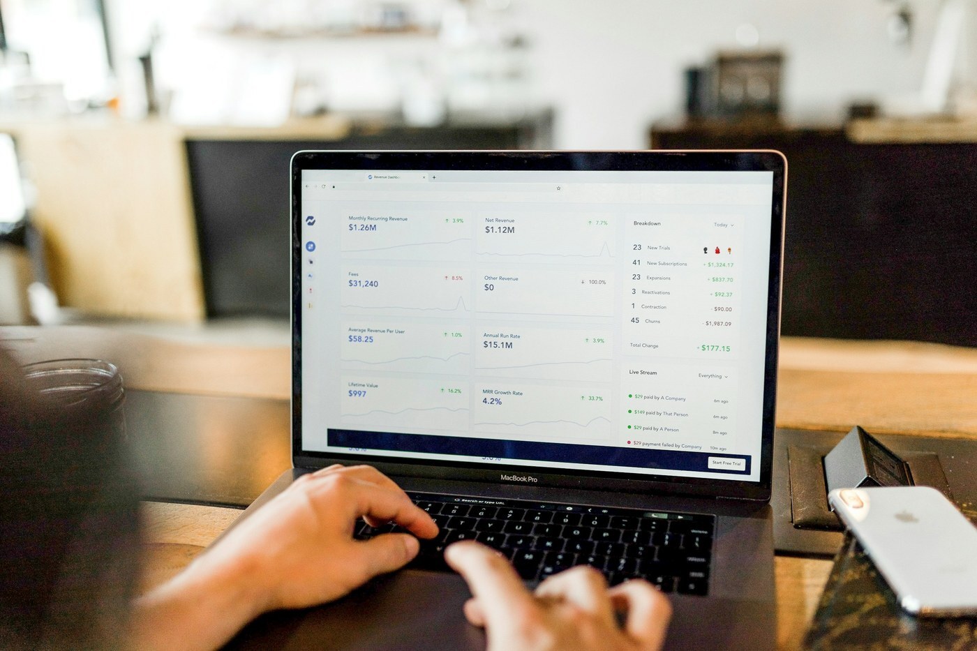 Hands typing on a laptop showing an inventory and revenue planning dashboard, representing Amazon AWD bulk storage and FBA replenishment planning