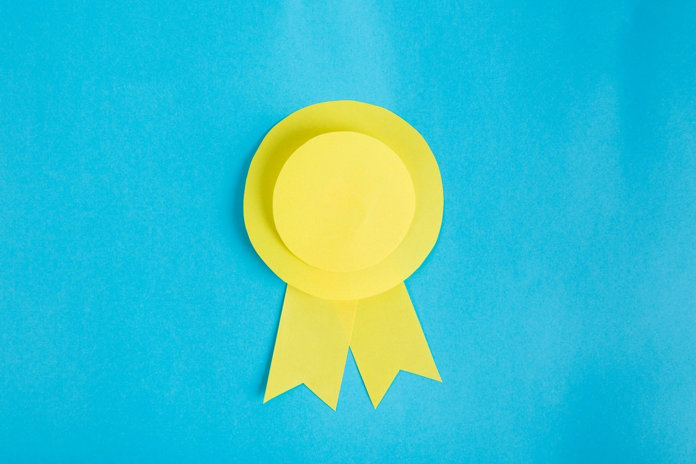 Yellow paper award seal on a bright blue background, representing authenticated brand quality protected by Amazon Transparency
